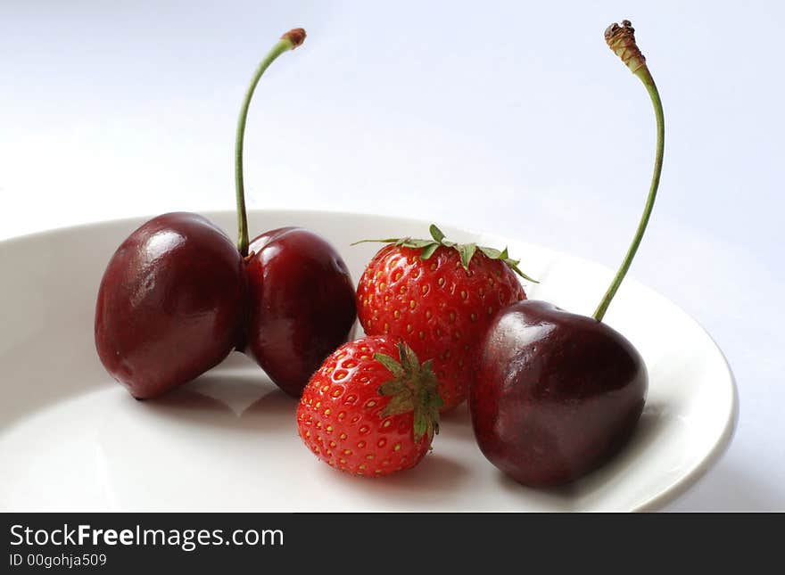 Sweet cherries and strawberries on a plate