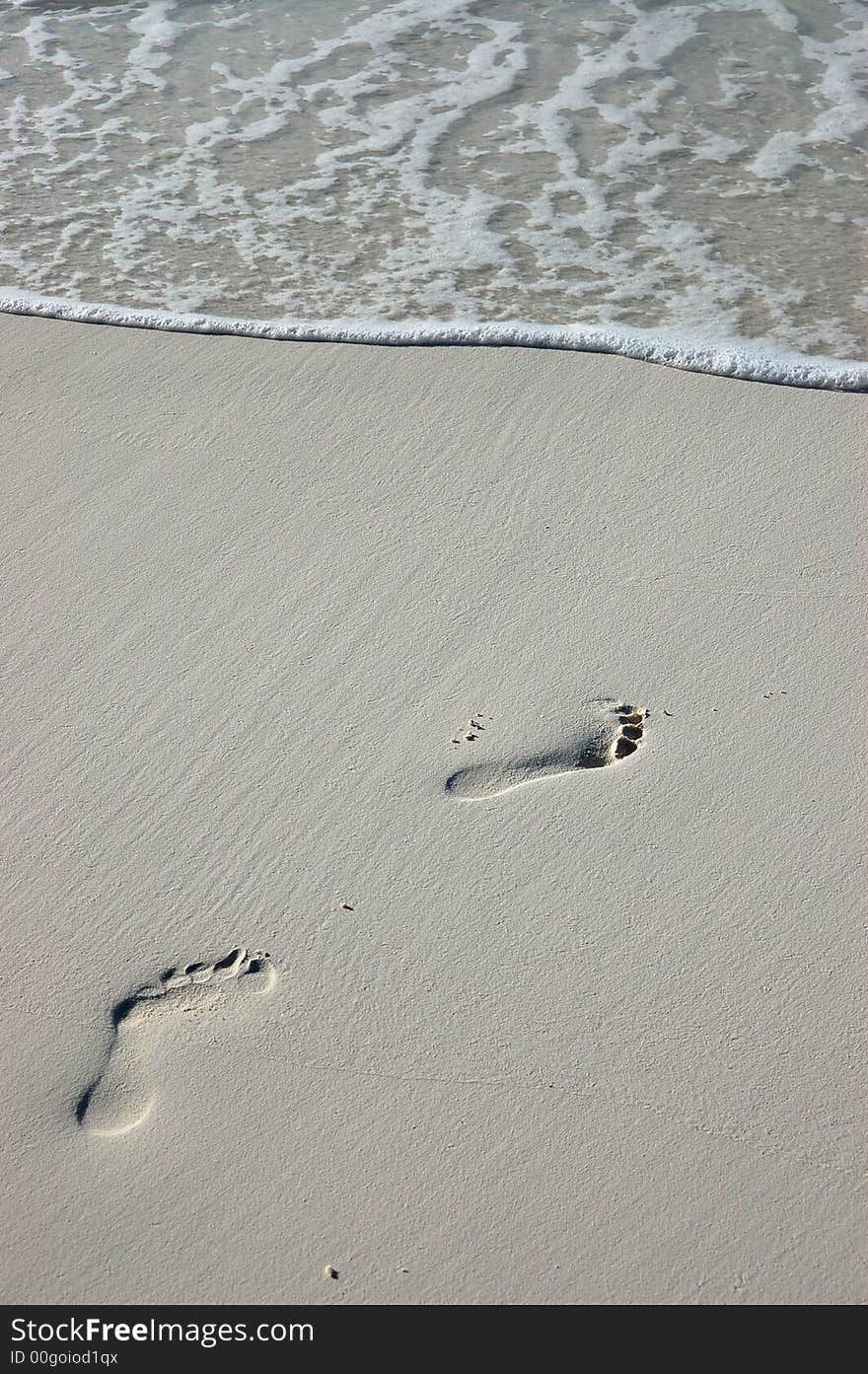 Footprints in the sand on a white maldivian beach