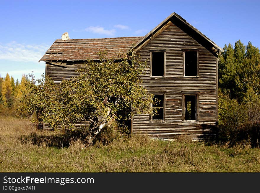 Medium long shot of an old, long-abandoned house taken on a country road in northern Michigan on a hot summer day. Medium long shot of an old, long-abandoned house taken on a country road in northern Michigan on a hot summer day.