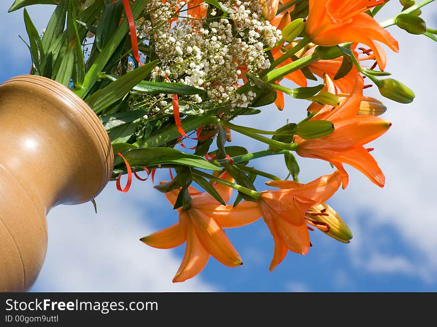 brown ceramic vase with bunch of flowers lily against heavens. brown ceramic vase with bunch of flowers lily against heavens