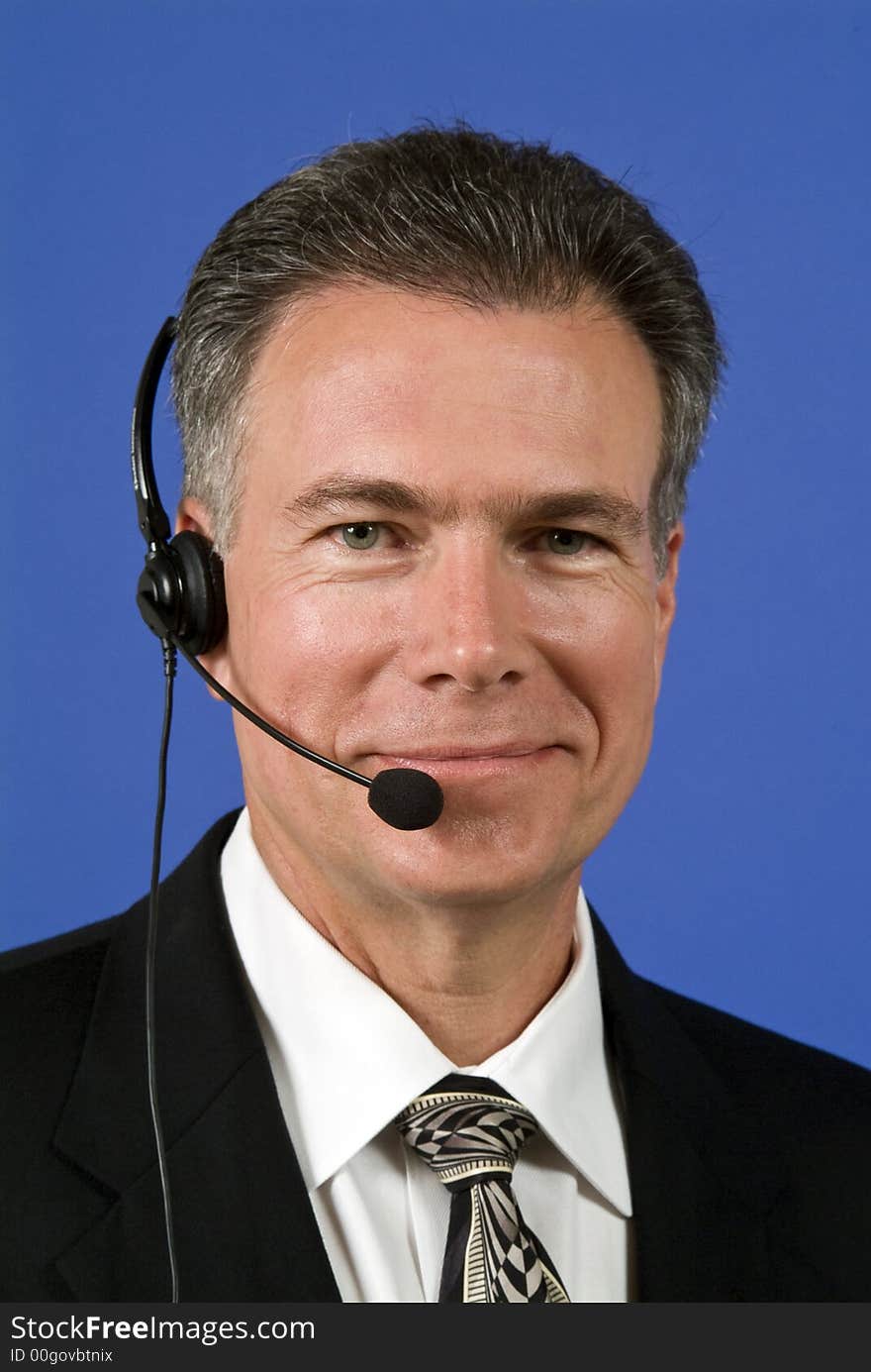 A man with a headset on as if manning a helpdesk or facilitating communication in some way. A man with a headset on as if manning a helpdesk or facilitating communication in some way.