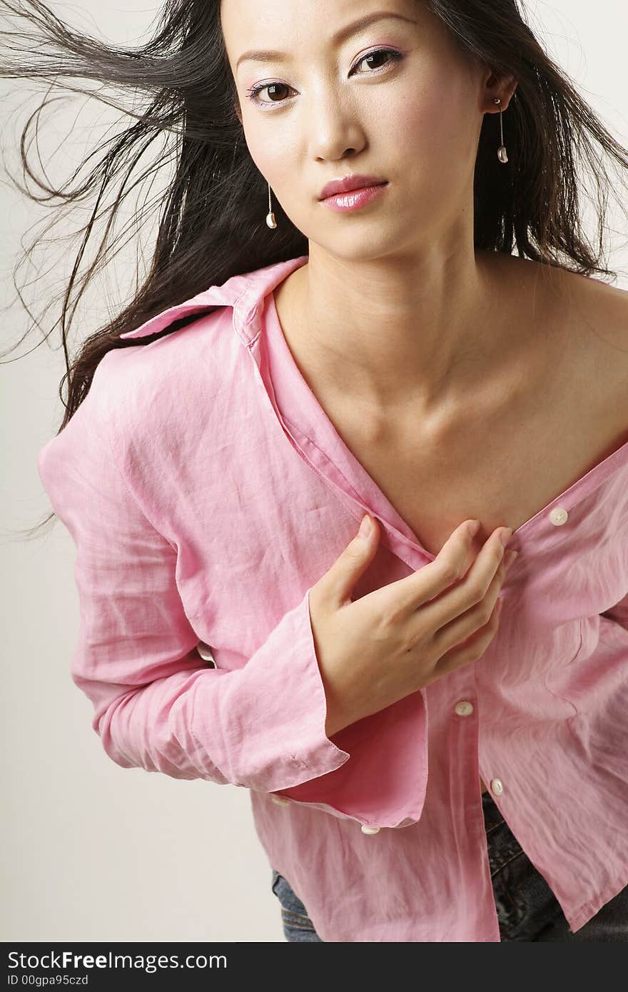 Enticing Chinese girl with flying hair in pink shirt