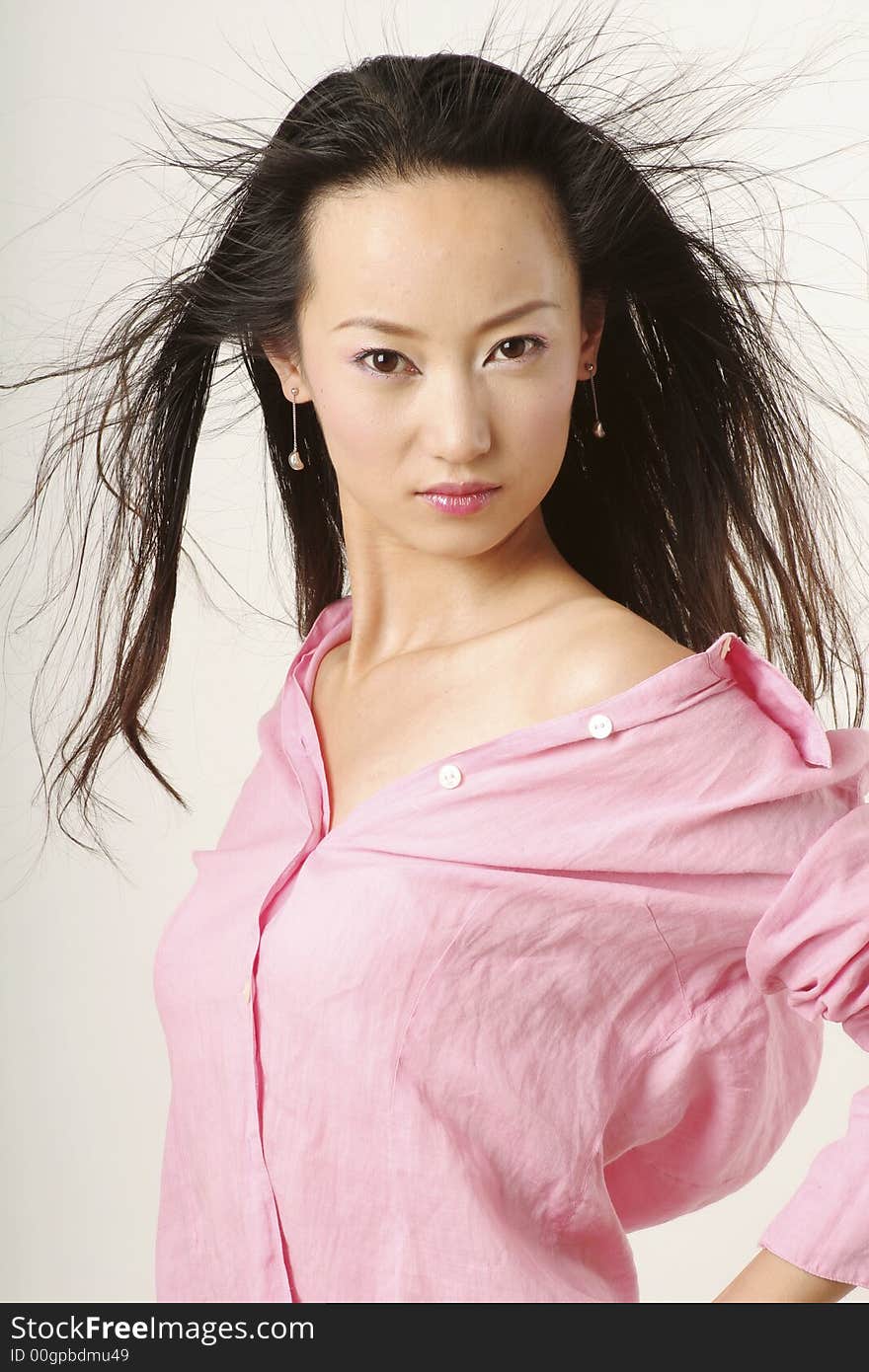 Enticing Chinese girl with flying hair in pink shirt