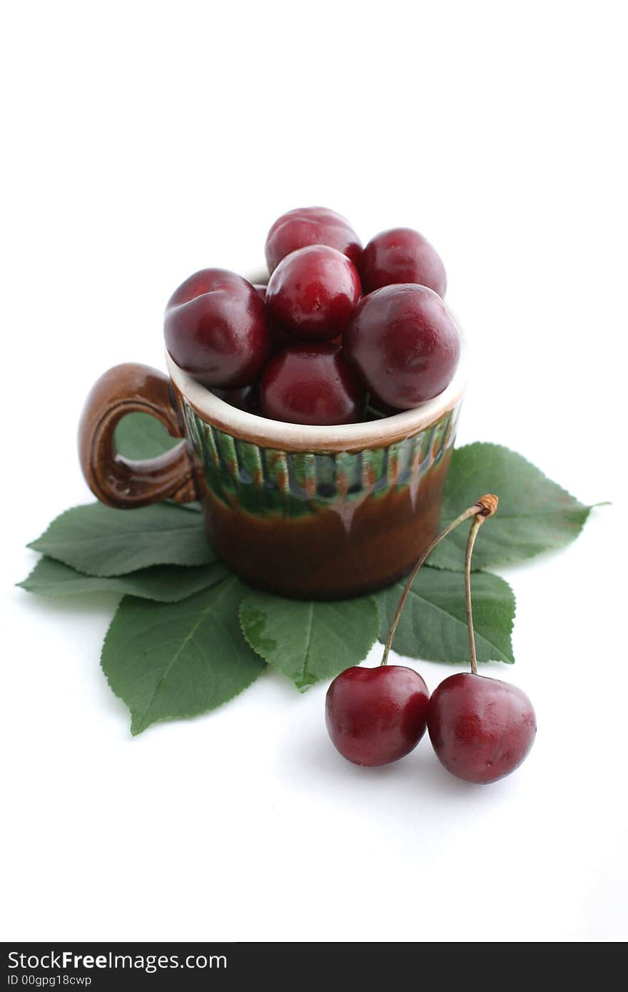 Cup of cherries isolated on white