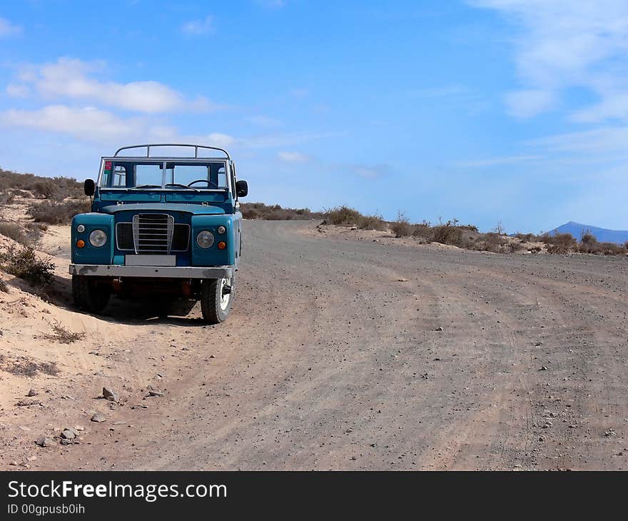 A 4WD picup truck parked at a desert country road. A 4WD picup truck parked at a desert country road