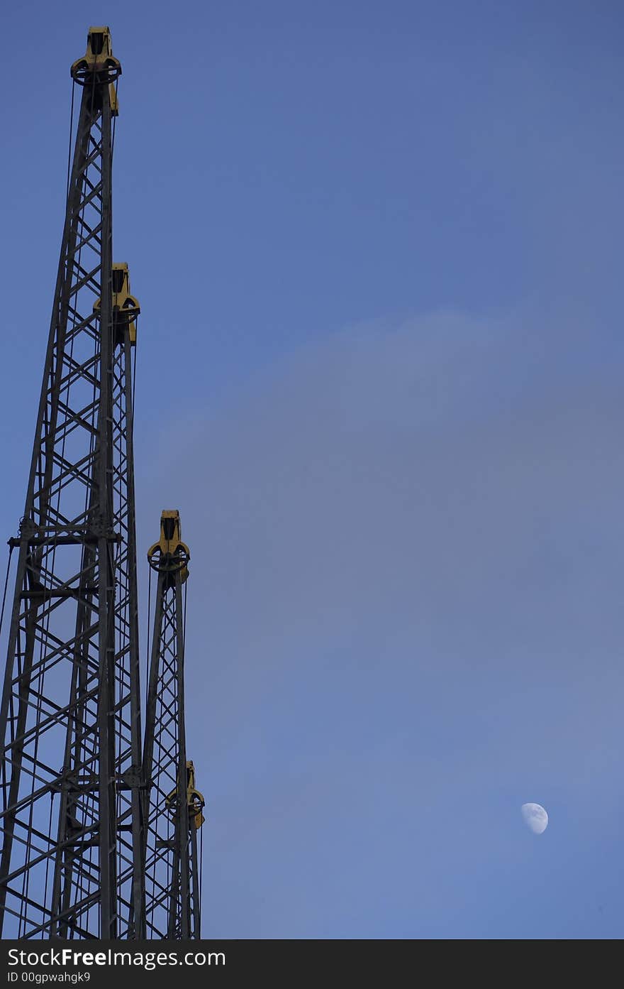 Cranes standing upright in a blue sky with a moon. Cranes standing upright in a blue sky with a moon