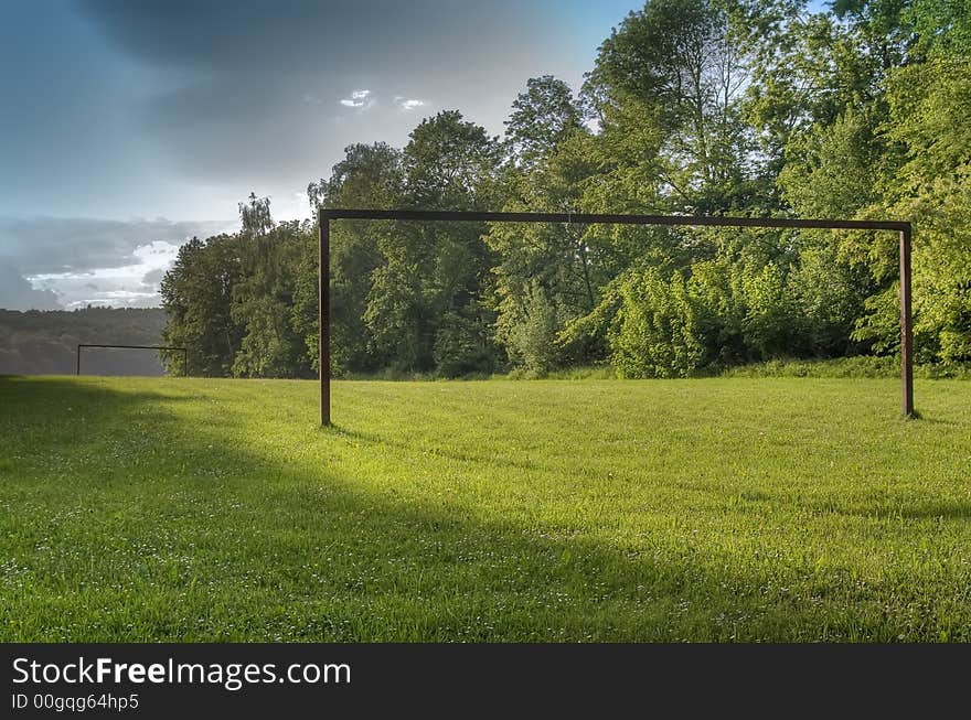 Green landscape with an empty gate