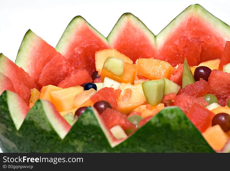 A watermelon carved into a basket filled with fresh fruit. A watermelon carved into a basket filled with fresh fruit.