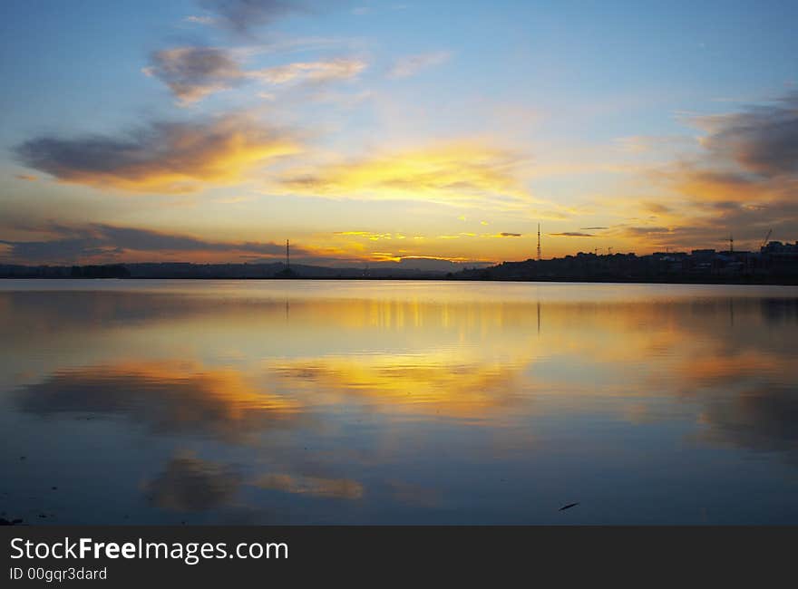 Sunset in the city. There is Angara river on foreground and distant city on the background.