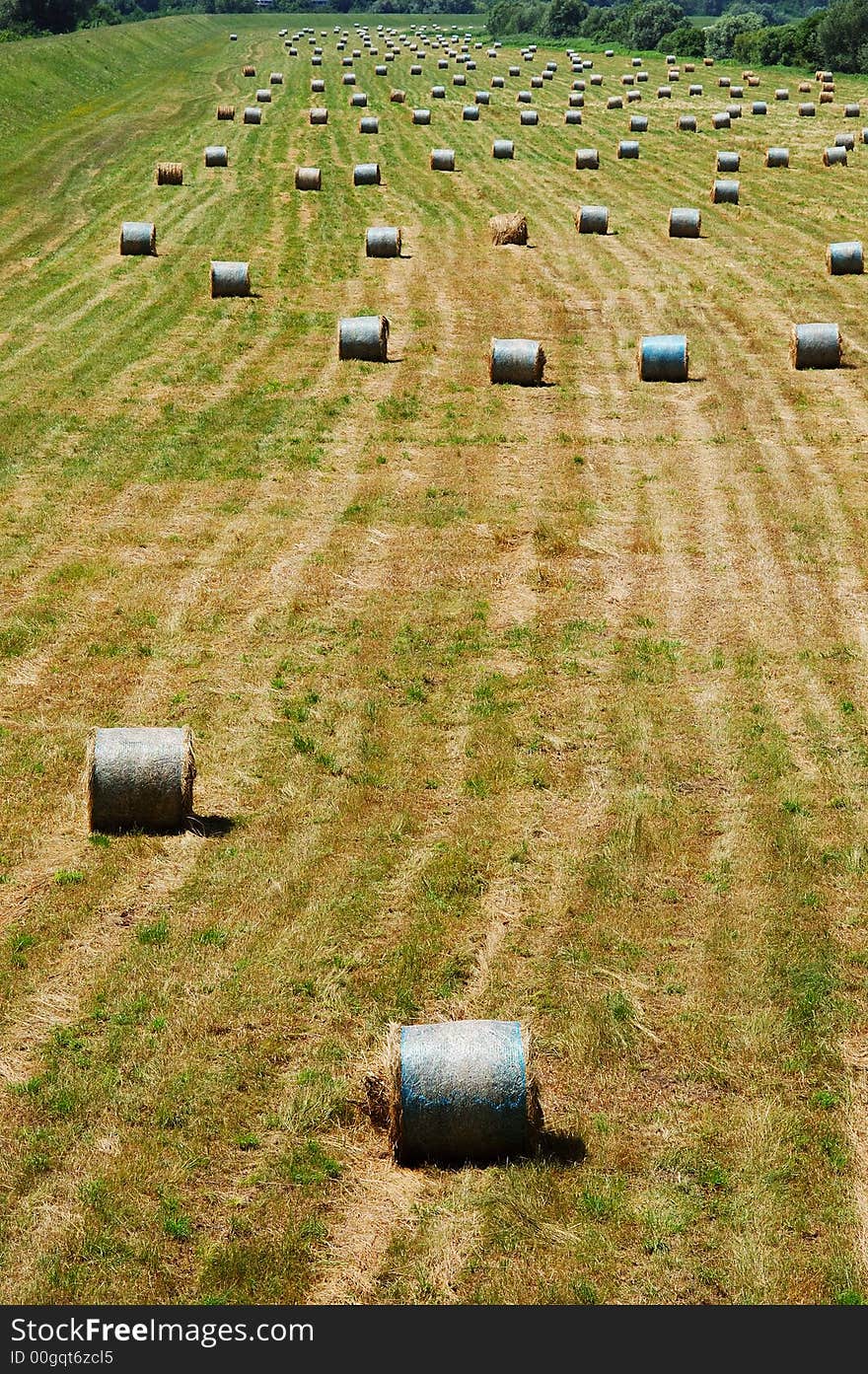 Straw bales endlessly spreading over field on a hot summer day. Straw bales endlessly spreading over field on a hot summer day