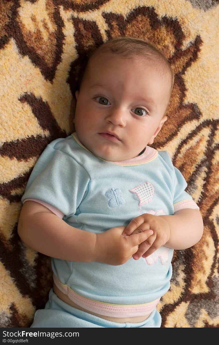 Small boy on brown carpet with cute look