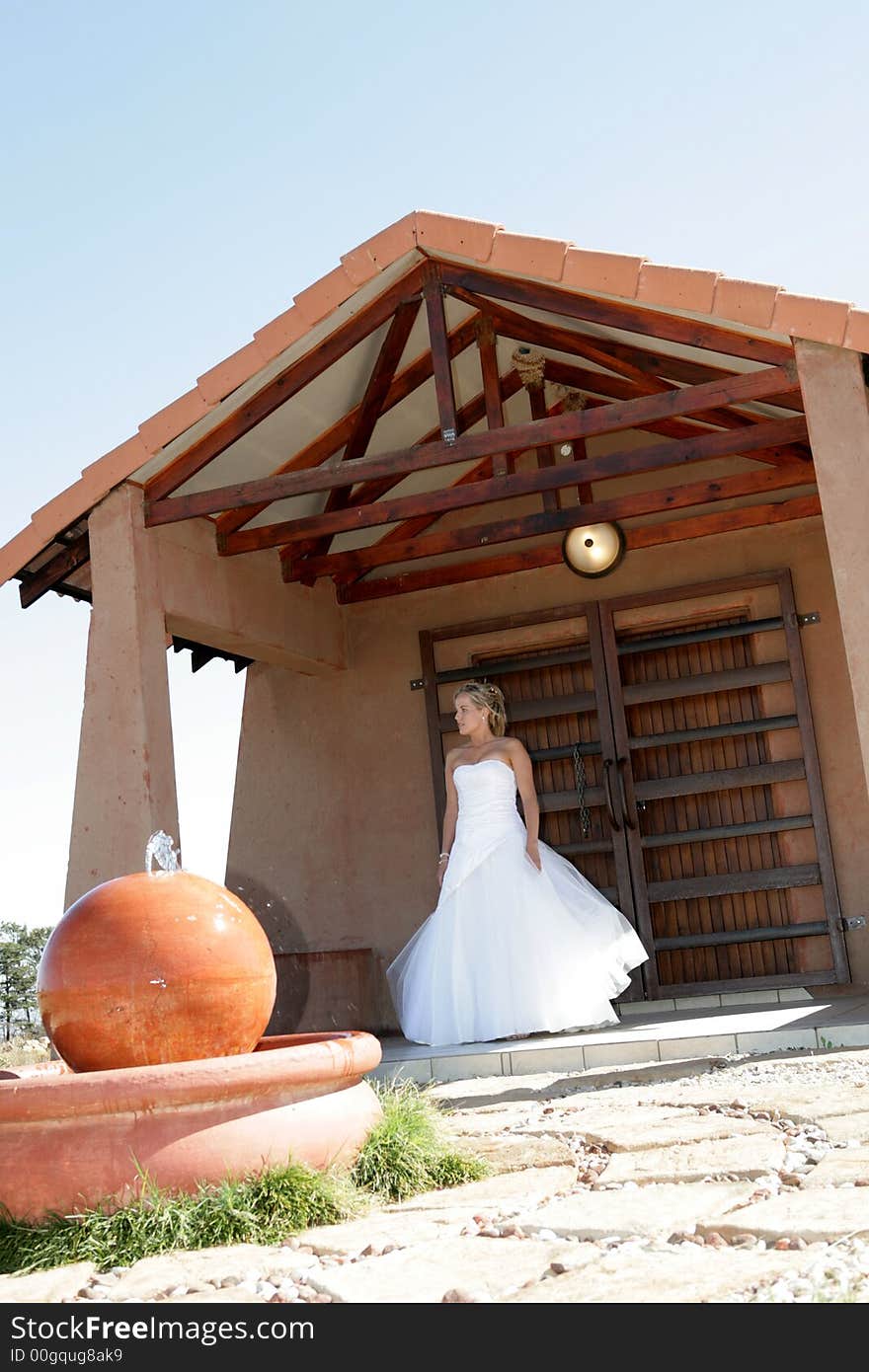 A bride standing on a porch in her dress. A bride standing on a porch in her dress