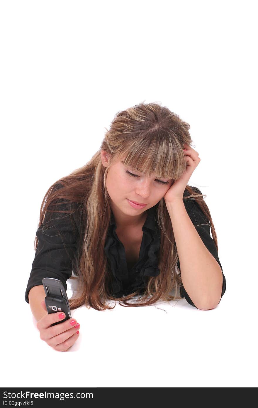 A dissatisfied woman laying with a phone in her hand on white background. A dissatisfied woman laying with a phone in her hand on white background