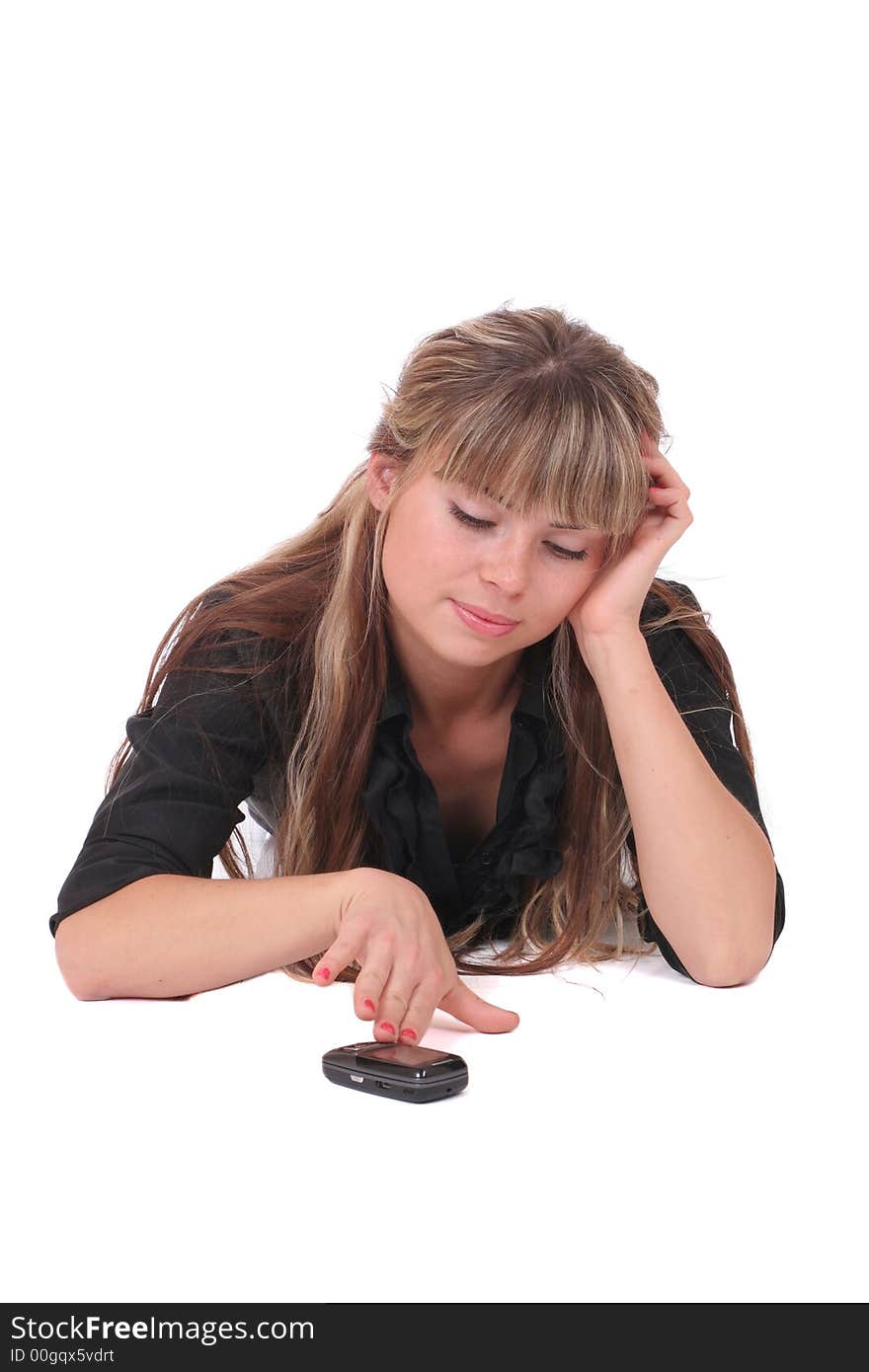 A dissatisfied woman laying with a phone in her hand on white background. A dissatisfied woman laying with a phone in her hand on white background
