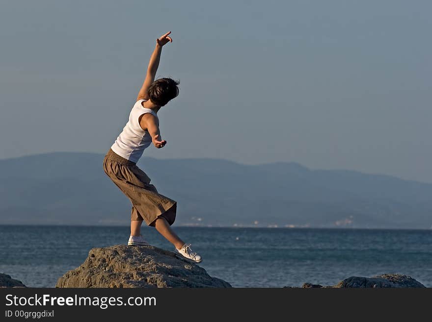 Woman making a exercise of balance at the seaside. Woman making a exercise of balance at the seaside