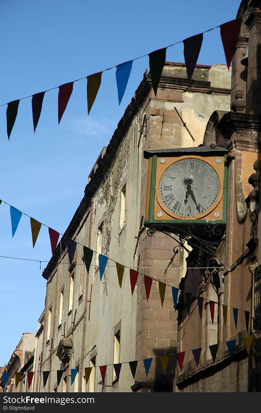 Party in a medieval little town in Italy with flags and clock tower. Party in a medieval little town in Italy with flags and clock tower