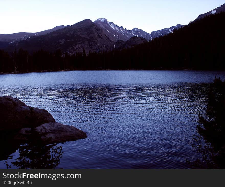 Mountains and lake showing shades of blue at dusk. Mountains and lake showing shades of blue at dusk.