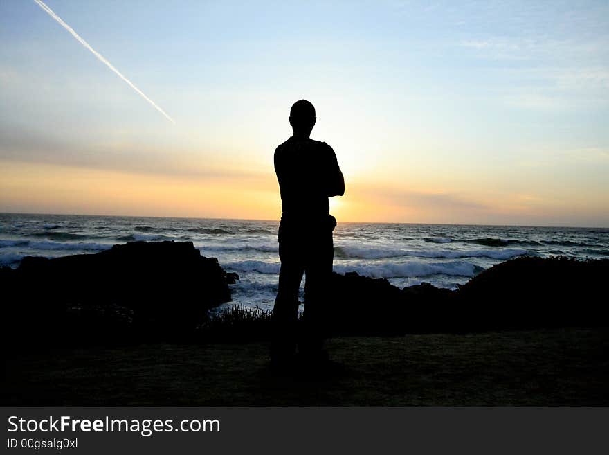 Man watching the sun set over the Pacific Ocean. Man watching the sun set over the Pacific Ocean