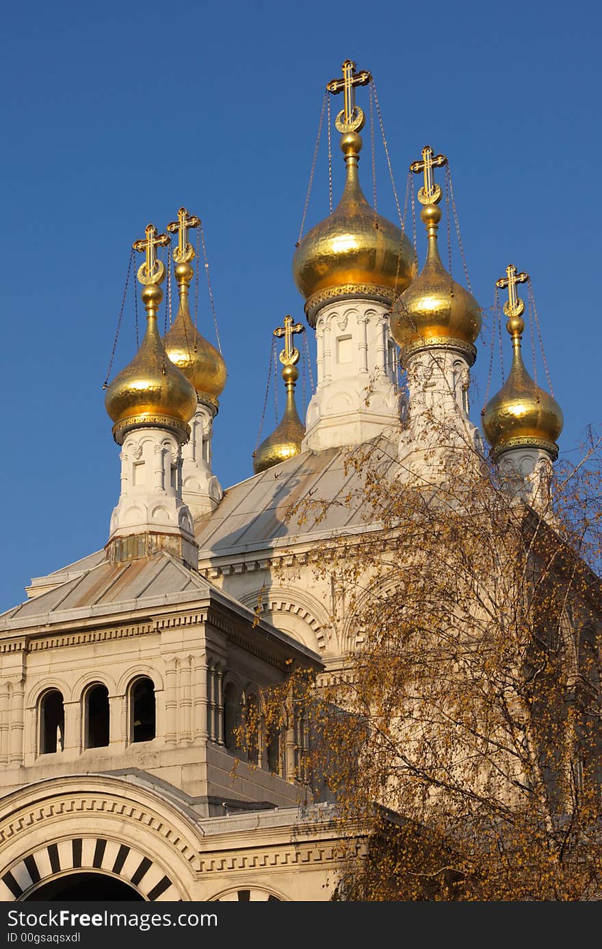 Gold cupolas, crosses and white walls of orthodox church in clear blue sky. Geneva, Switzerland. Gold cupolas, crosses and white walls of orthodox church in clear blue sky. Geneva, Switzerland.