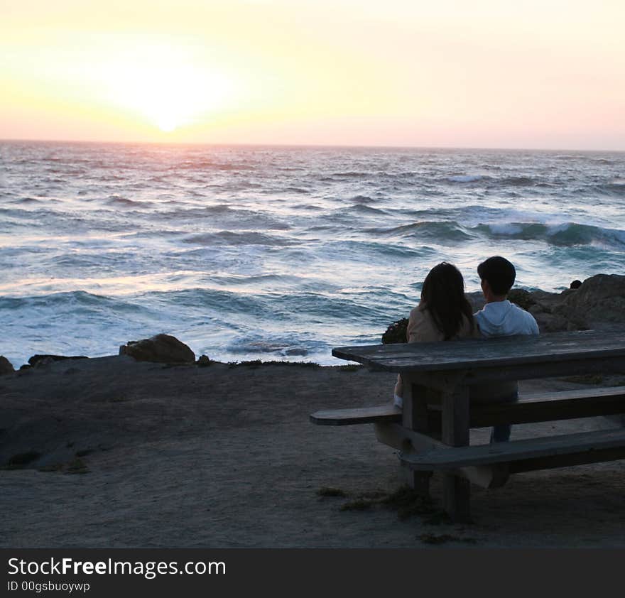 Couple watching the sun set over the Pacific Ocean. Couple watching the sun set over the Pacific Ocean