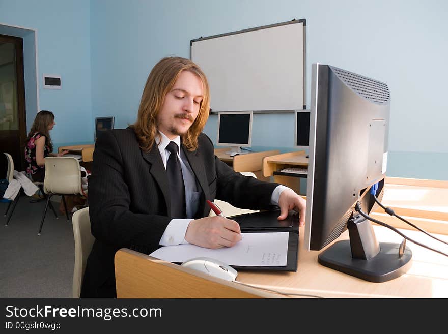 Young businessman is talking by mobile phone & also receives the information by computer.