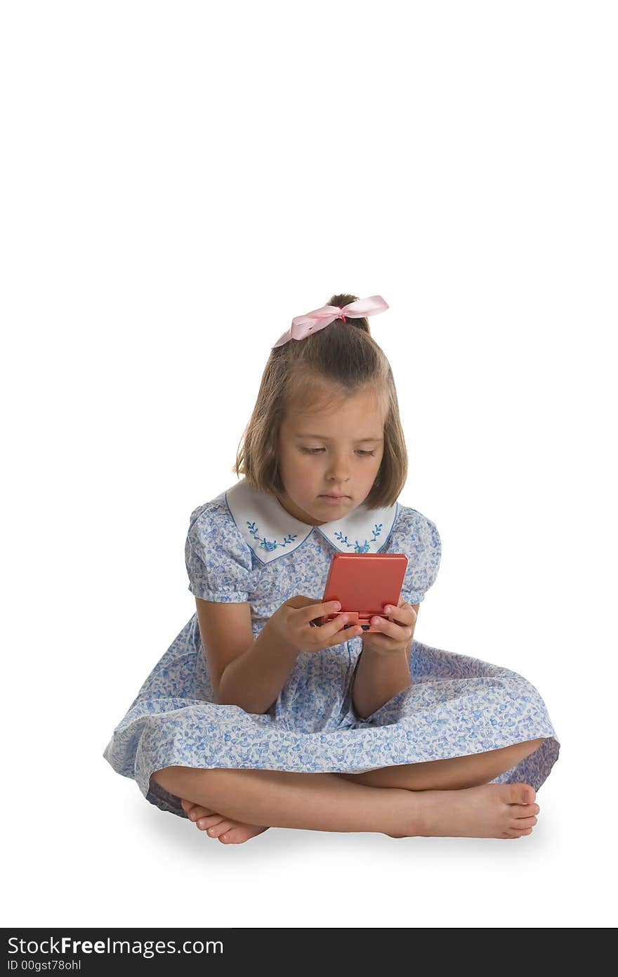 A young, Caucasian girl playing an electronic game. Isolated on white. A young, Caucasian girl playing an electronic game. Isolated on white.