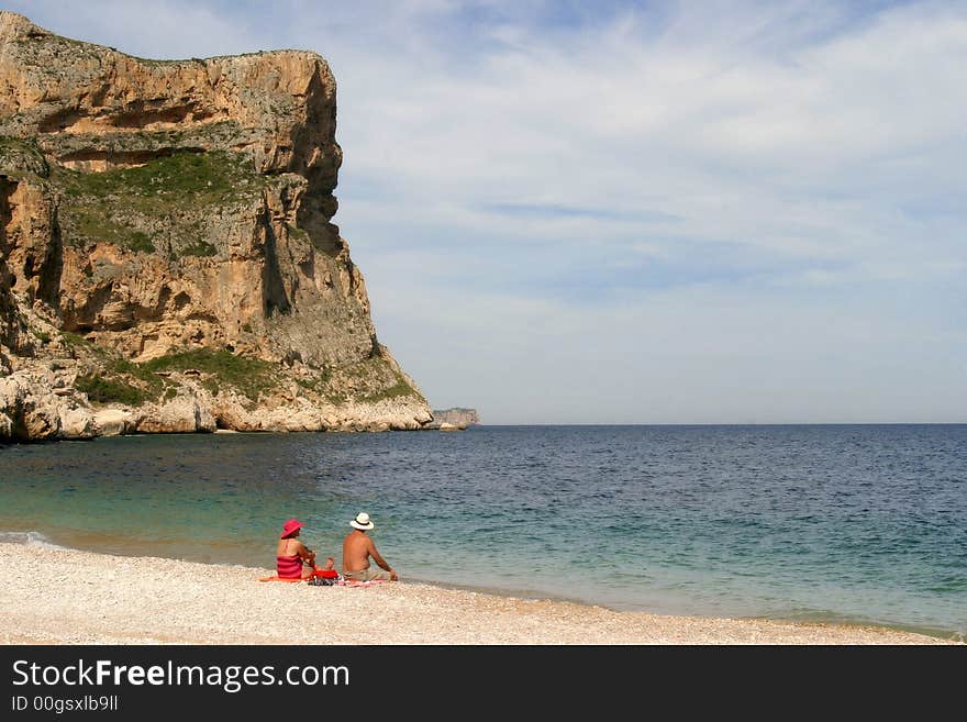 A couple sitting near the sea. A couple sitting near the sea