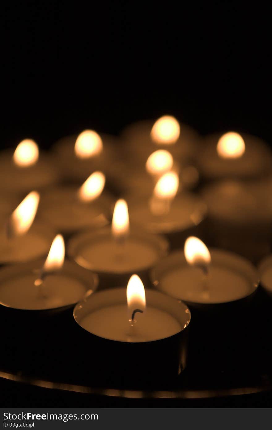 Set of candles all lit over black background. Set of candles all lit over black background