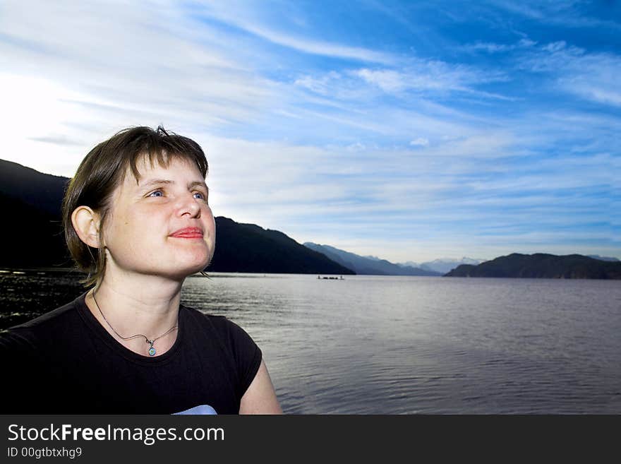 Woman enjoying a scenery over blue sky. Woman enjoying a scenery over blue sky