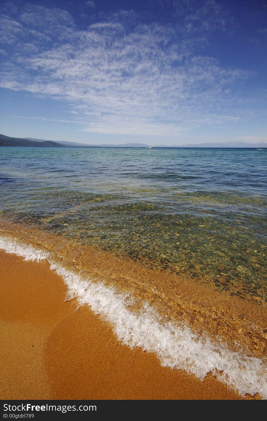 Waves from lake tahoe flowing over yellow sand. Waves from lake tahoe flowing over yellow sand