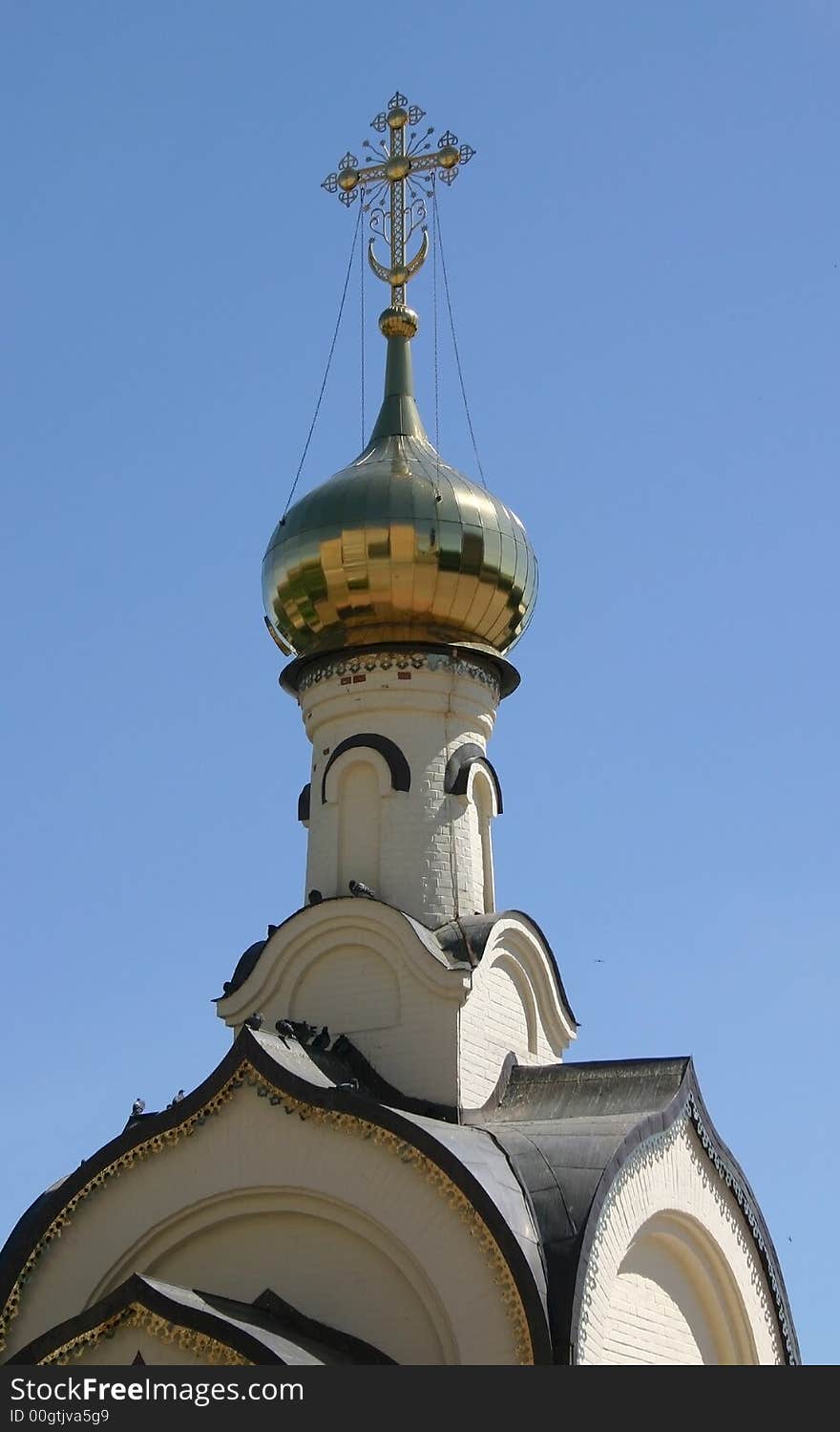 The dome of church with a gold cross is photographed on a background of the sky