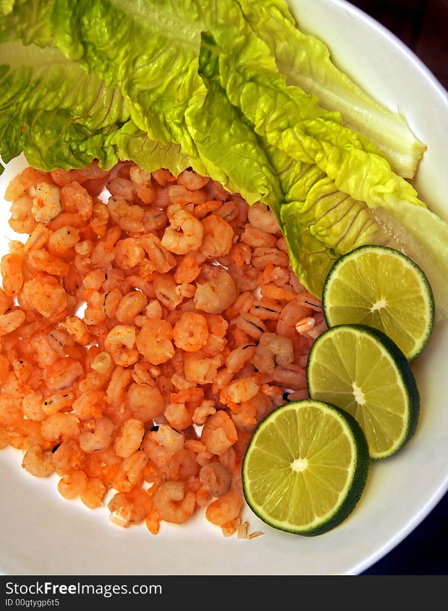 Shrimps on the plate with the limes and salad