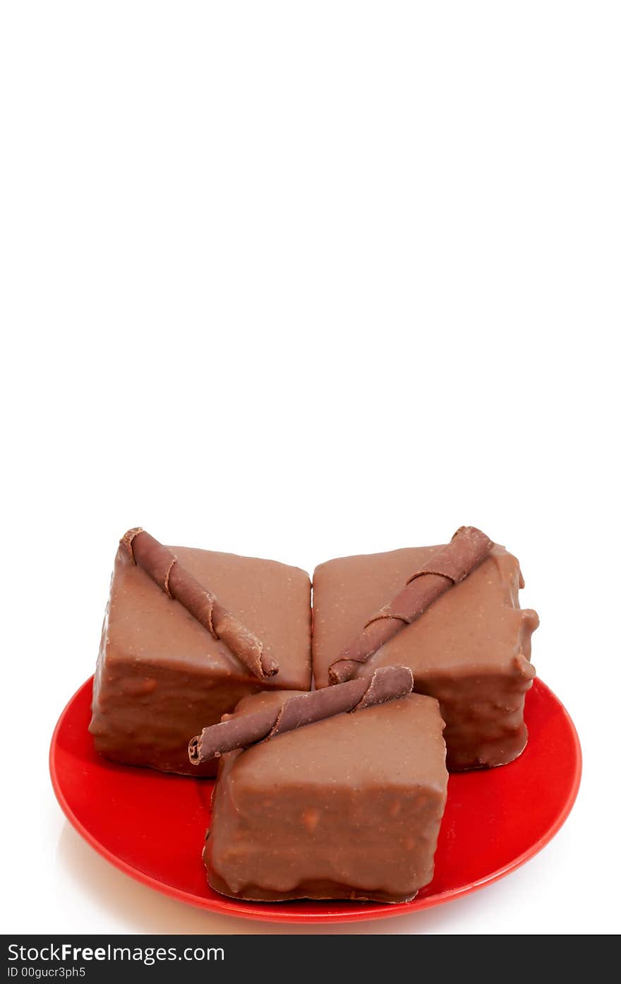 Two chocolate mini cakes on red plate, shot on white background. Two chocolate mini cakes on red plate, shot on white background