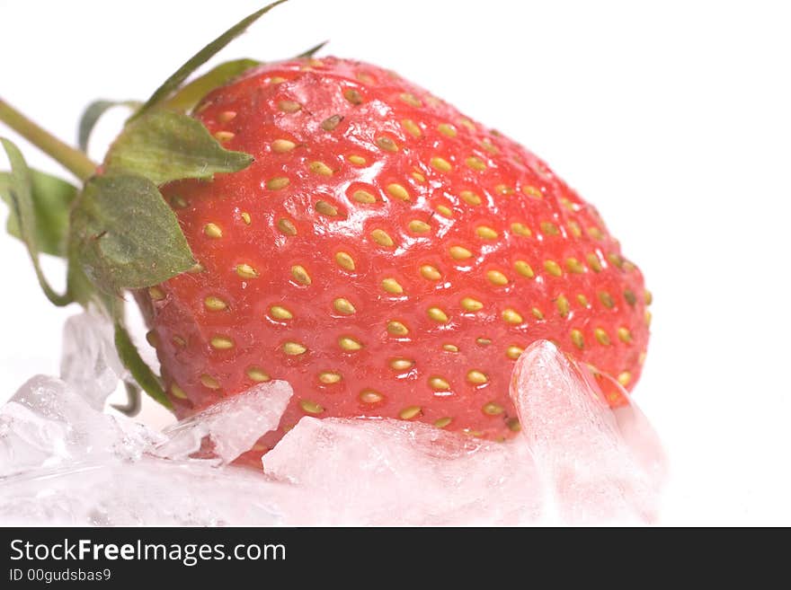 Fresh strawberry on ice chips against a white background