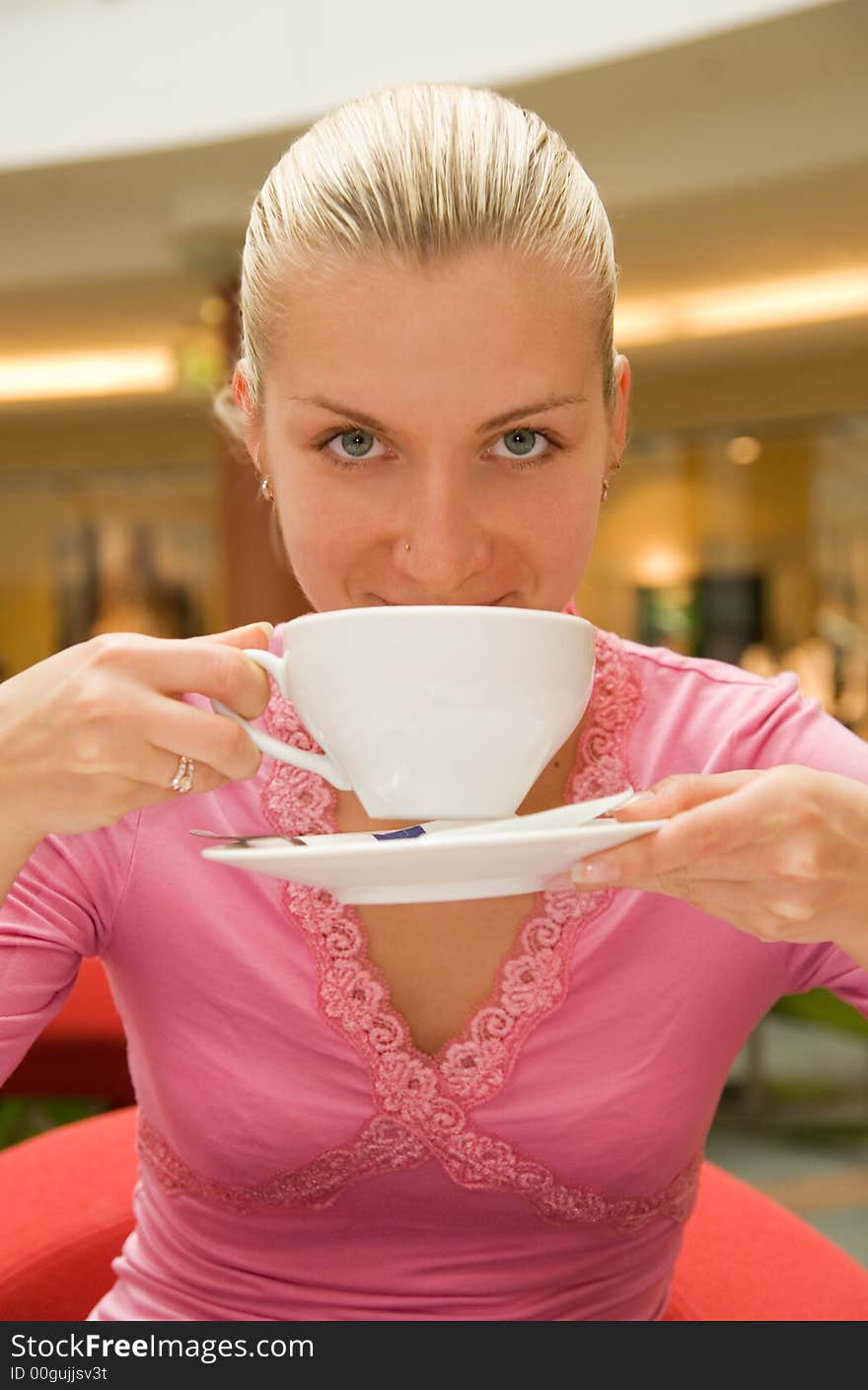 Attractive blond girl drinking coffee in a restaurant