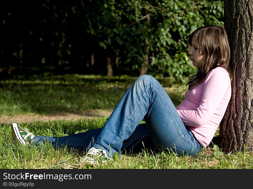 Little girl sitting under the tree. Little girl sitting under the tree