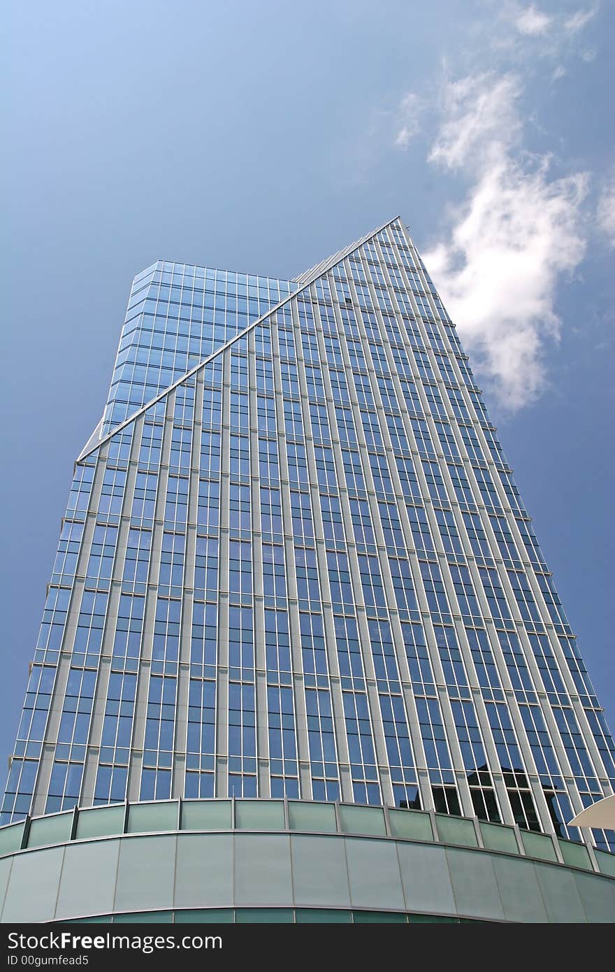 Modern glass building rising into the clouds. Modern glass building rising into the clouds