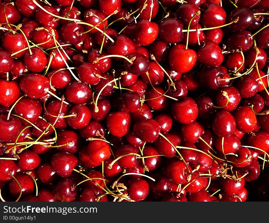 Red sweet cherries in bright sunshine, background. Red sweet cherries in bright sunshine, background