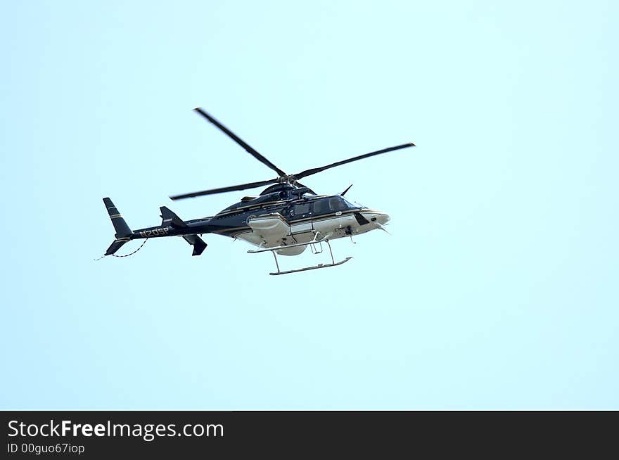 A Private Heliocopter flying against a Blue Sky. A Private Heliocopter flying against a Blue Sky