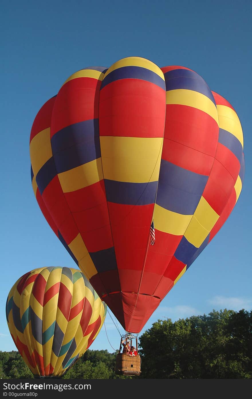 Two colorful hot air balloons waiting to take off into the blue summer sky