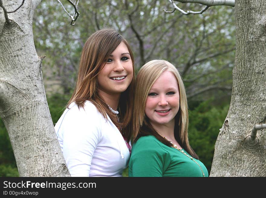 Best Friends smiling framed between two trees