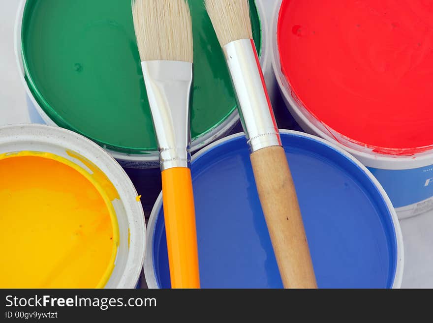 Vertical picture of paints in red,blue,green and yellow and brushes. Vertical picture of paints in red,blue,green and yellow and brushes