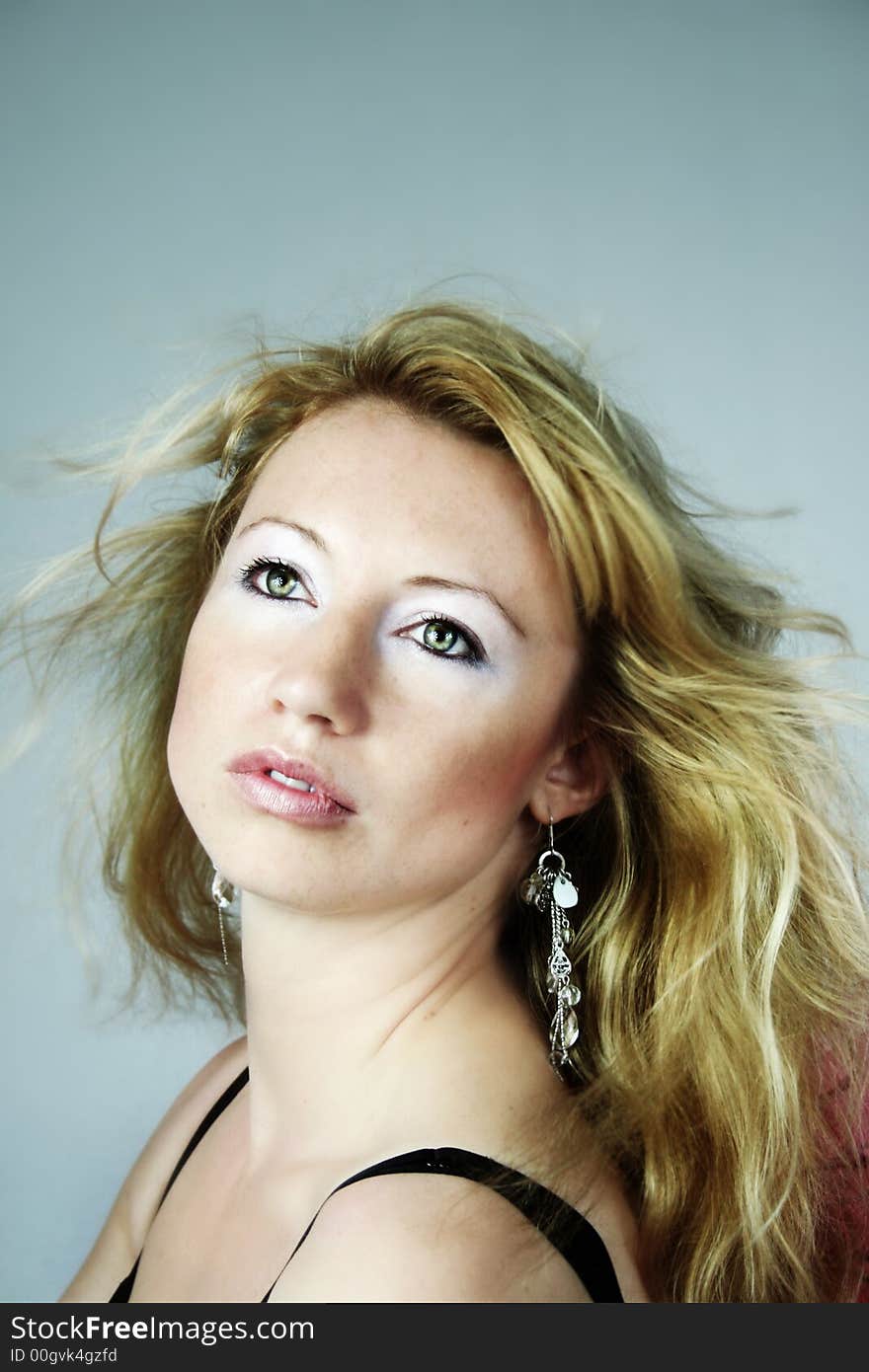 Beauty portrait of a woman with earrings and wind on her hair. Beauty portrait of a woman with earrings and wind on her hair