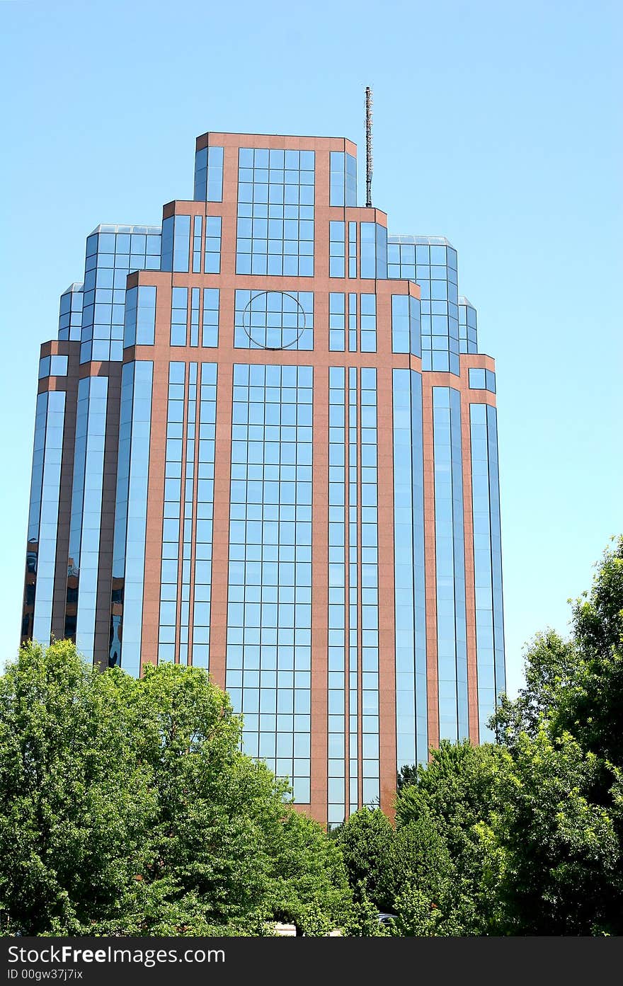 Brick and glass building rising from the trees