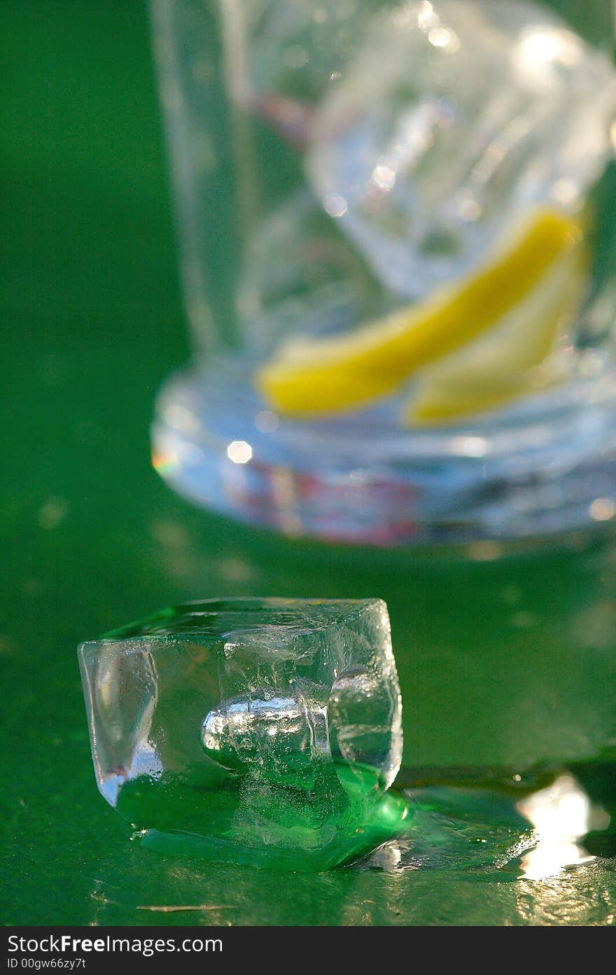 Photography of an ice cube on a table with a glass