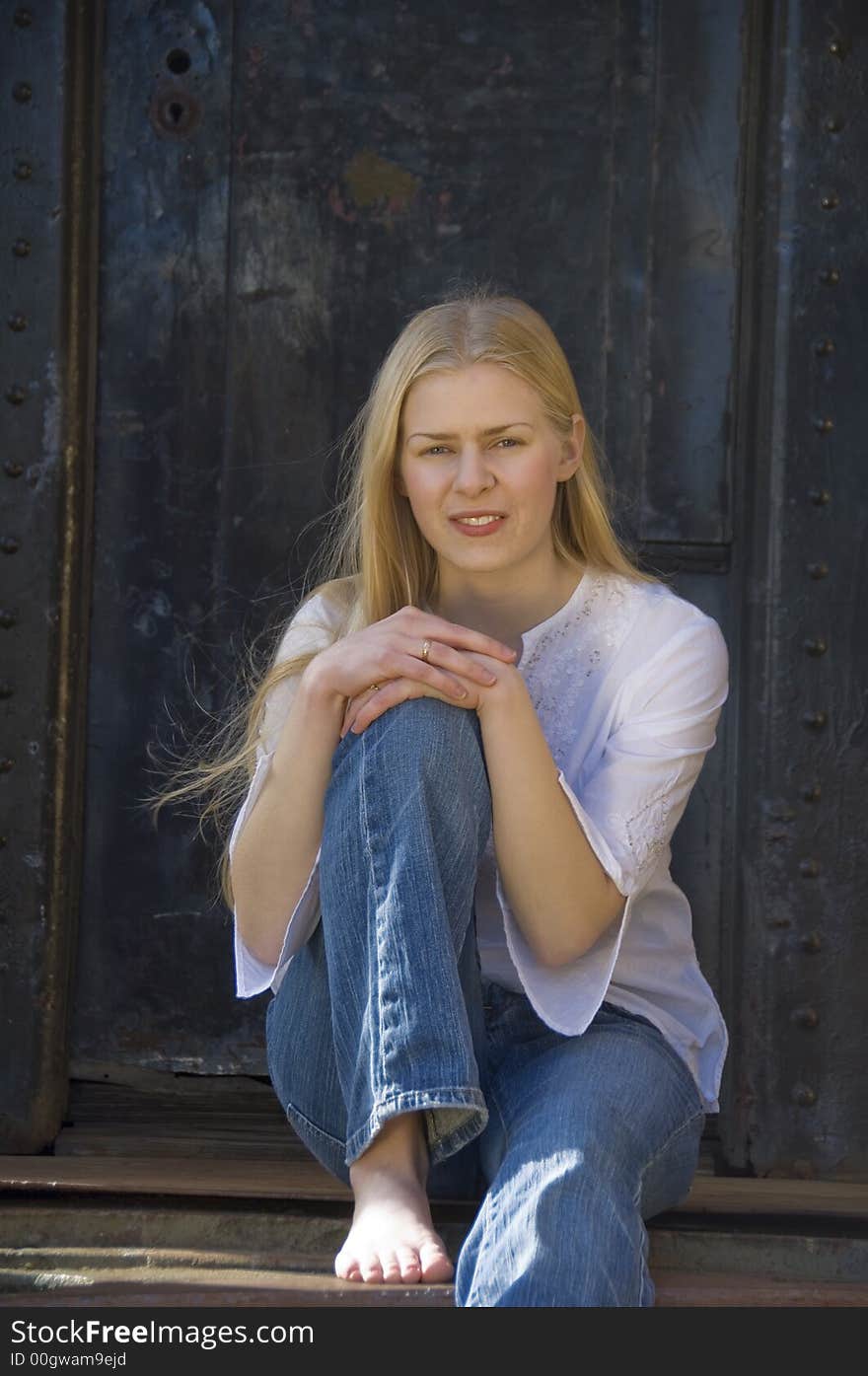 Young blond woman gazing at the camera with a pretty smile. Young blond woman gazing at the camera with a pretty smile.