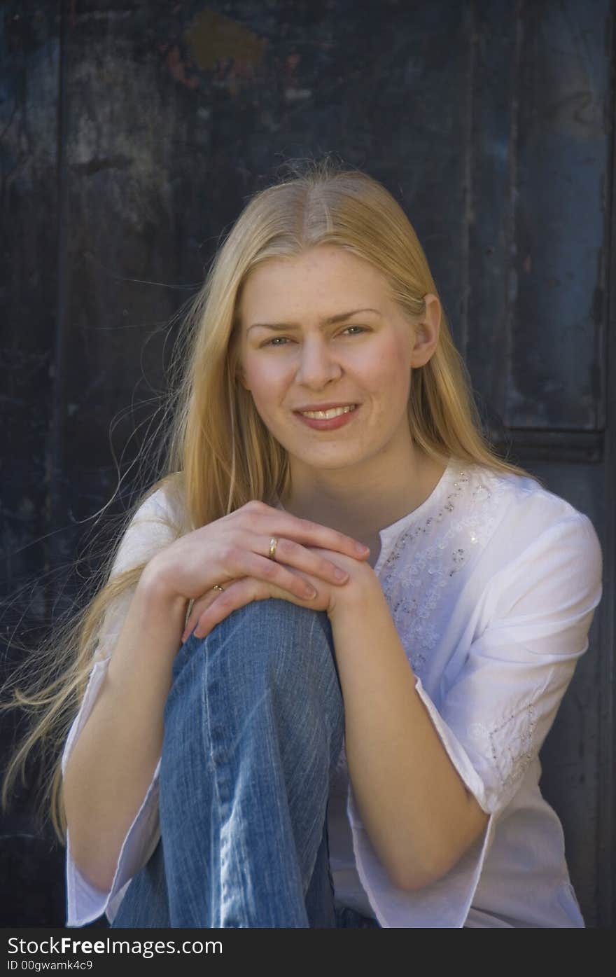 Young blond woman gazing at the camera with a pretty smile. Young blond woman gazing at the camera with a pretty smile.