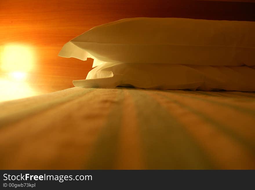 Extreme angle on a dimly lit bed and pillows