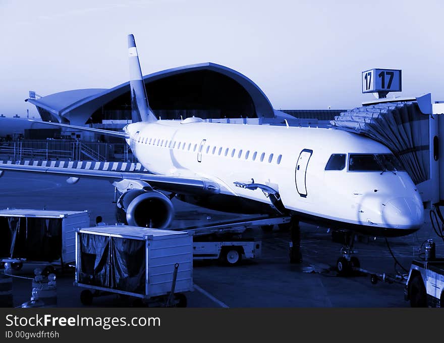 Plane ready for departure, early morning flight. Blue monochrome