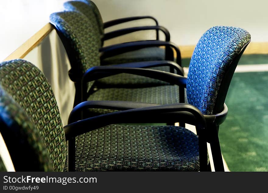 Standing out - one chair standing out in a row of office chairs - selective focus on different chair